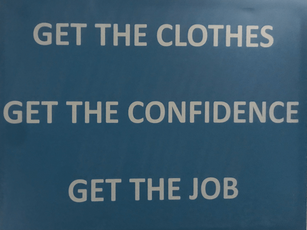 A blue sign reading, "Get the clothes, get the confidence, get the job."